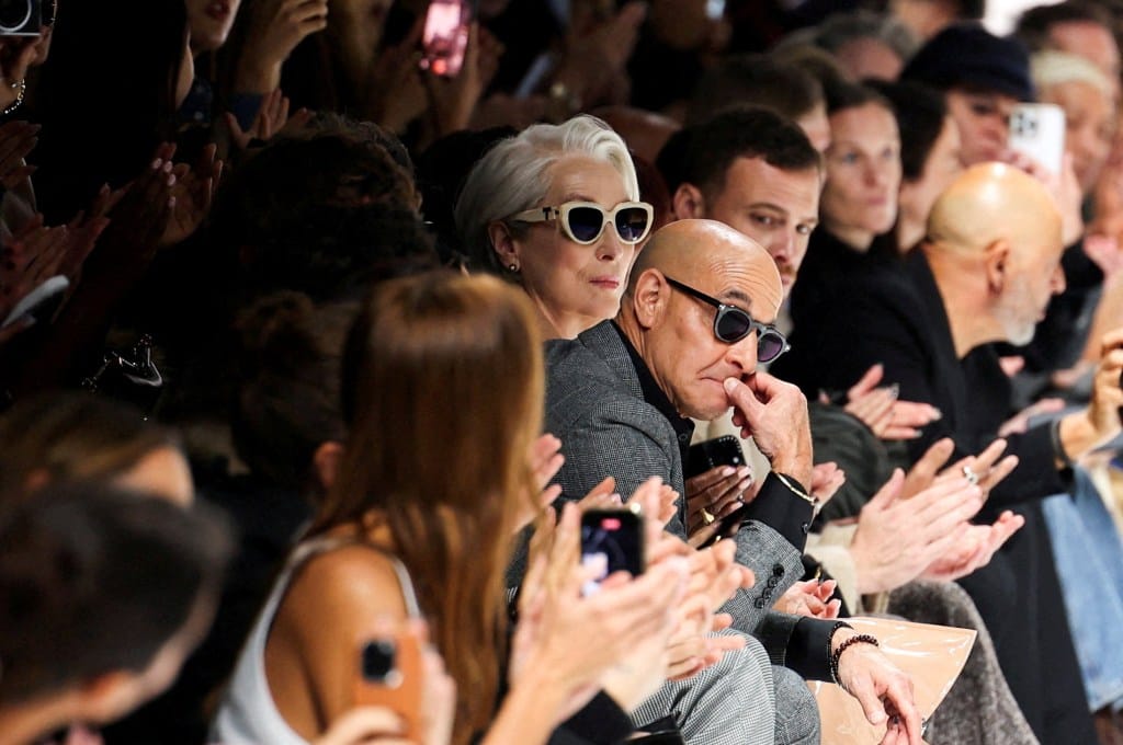 Meryl Streep, in sunglasses, and Stanley Tucci, in a grey jacket and sunglasses, watching the Dolce &amp; Gabbana fashion show.