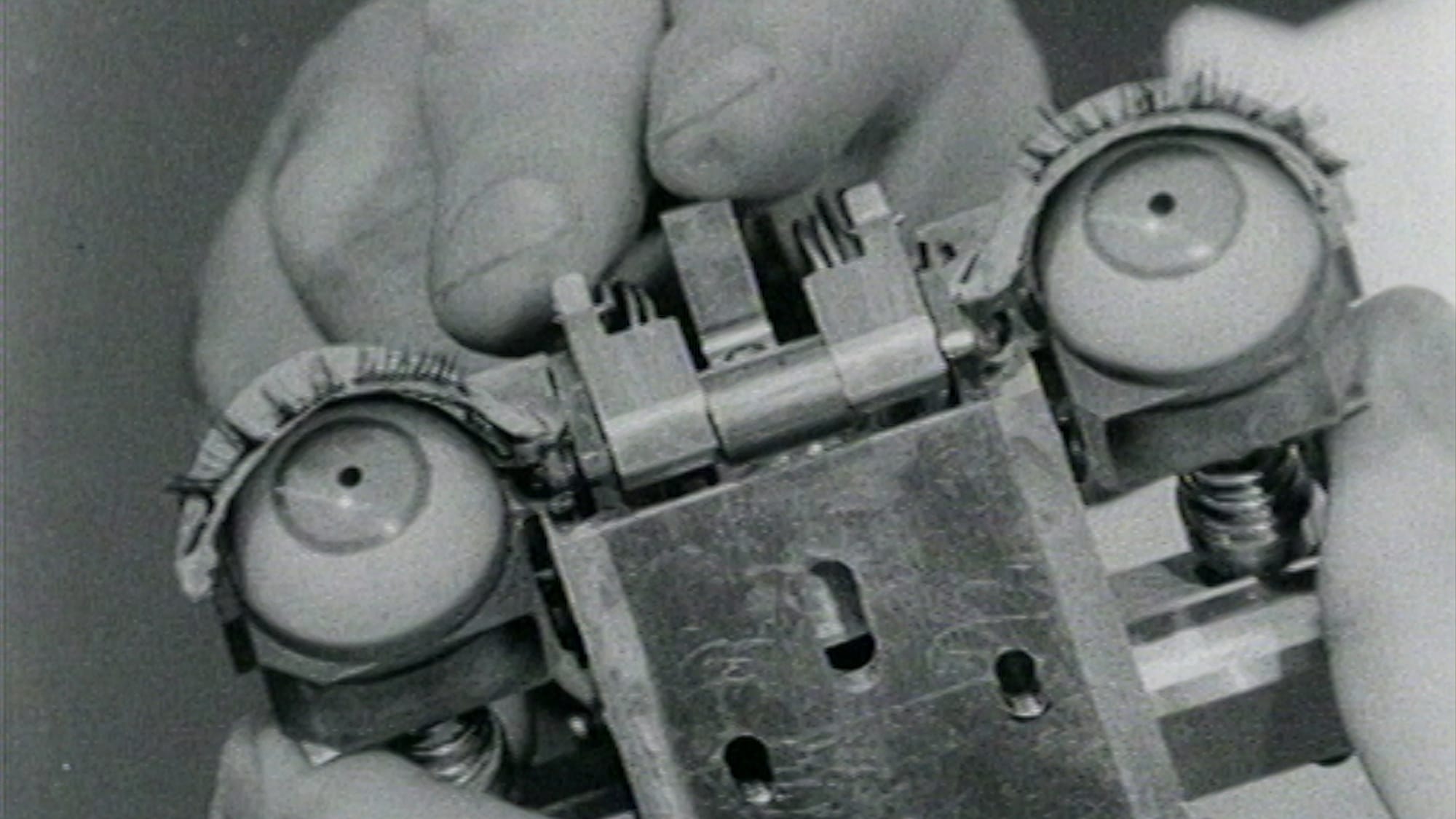 A photo of a hand holding the mechanical eyes of humanoid machine.